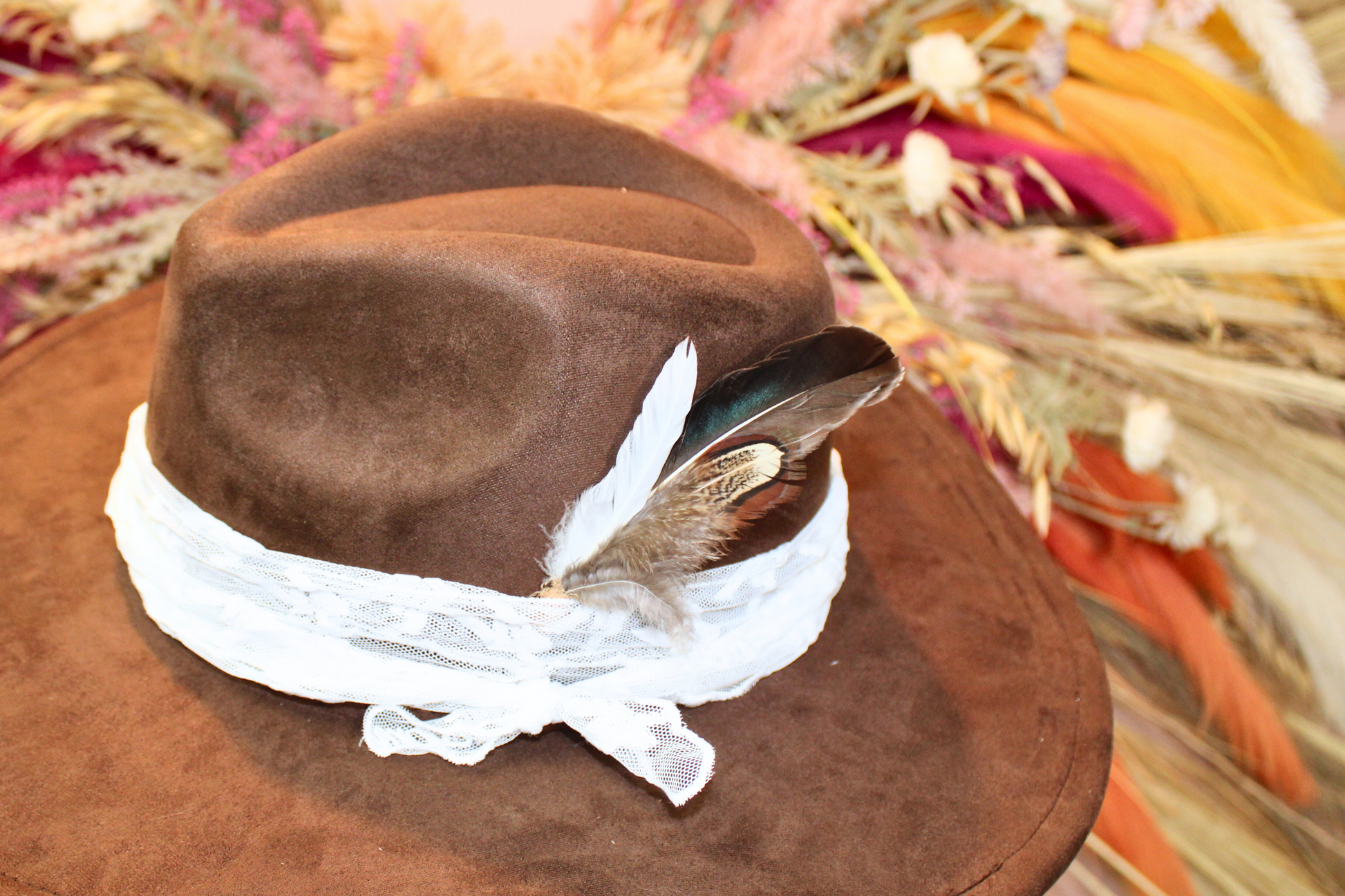 Brown hat with a feather and lace ribbon on a colorful floral background
duck and pheasant feather small hat pick hat feather