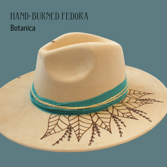 Hand-burned Fedora with botanical design and teal band on a solid background