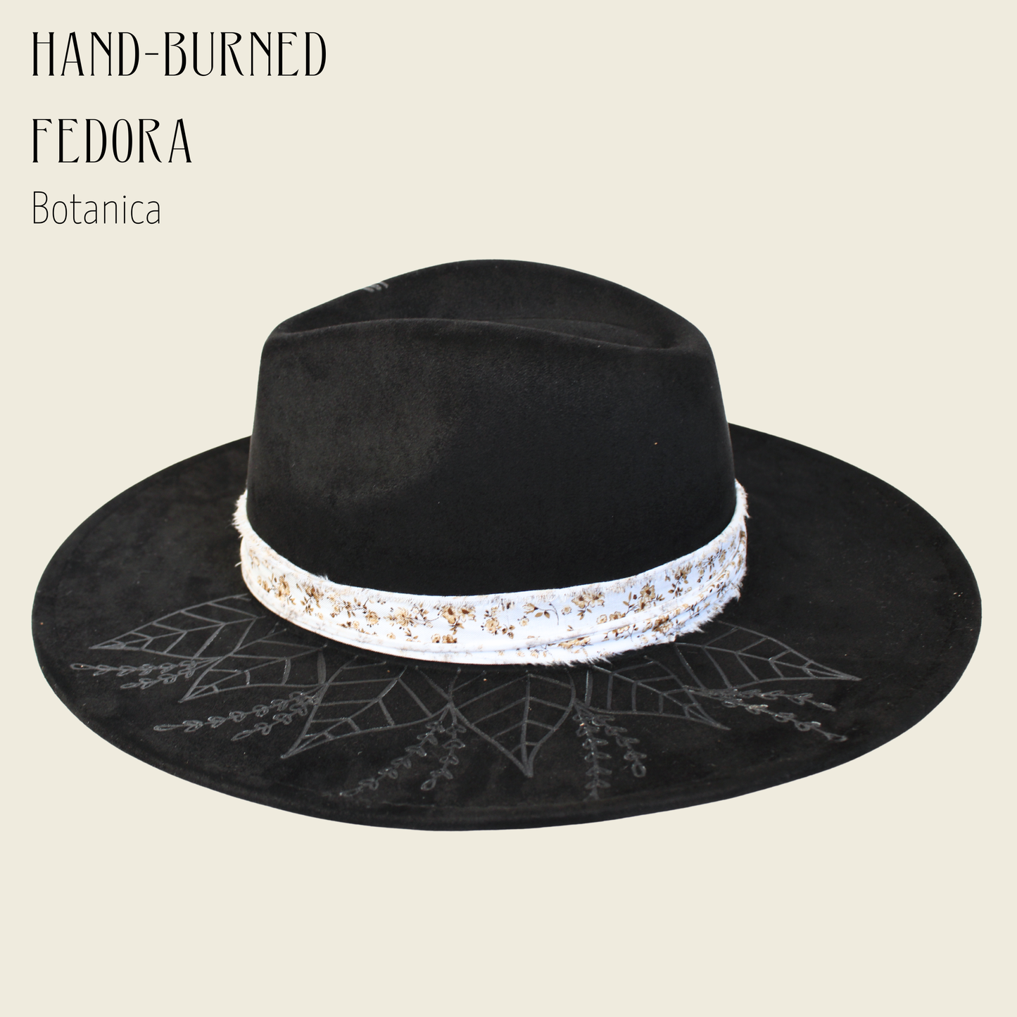 Black fedora hat with decorative band on a beige background