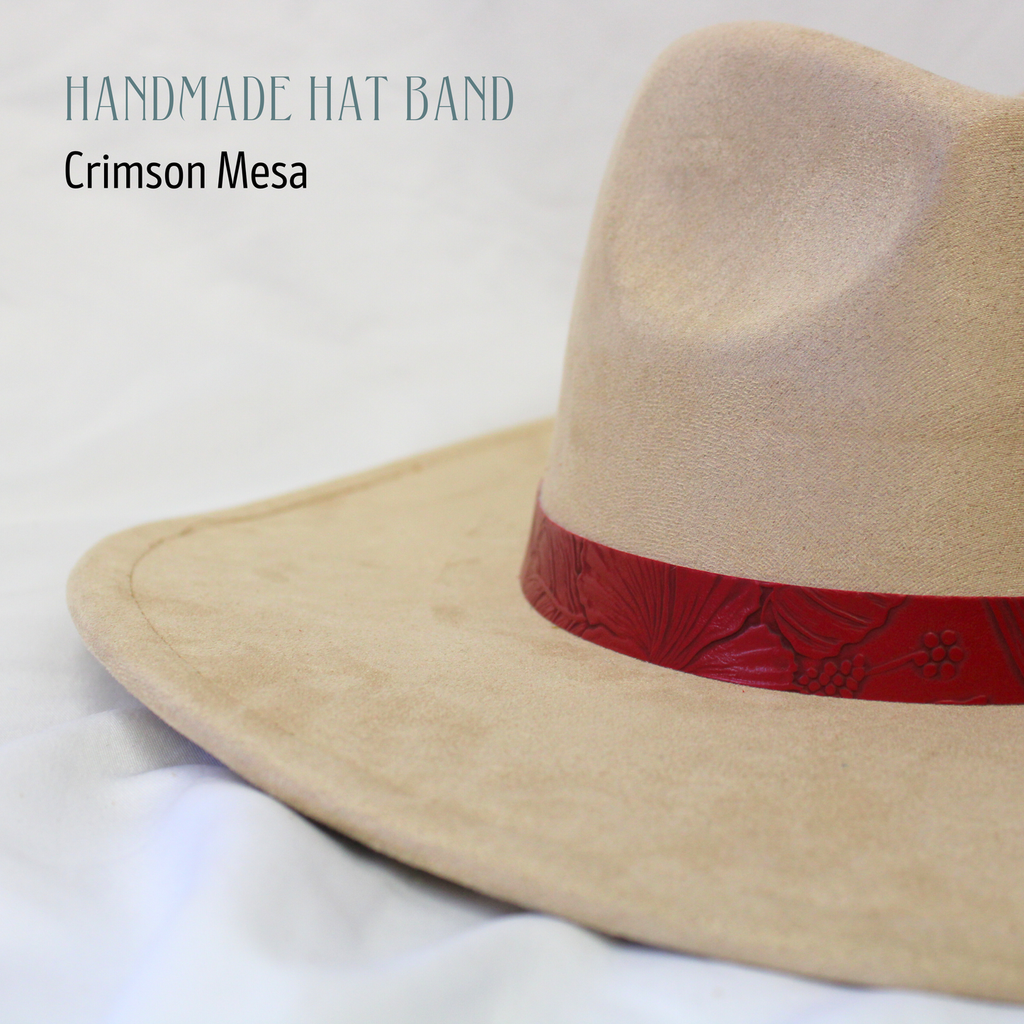 Beige cowboy hat with a red band on a white background, labeled 'Handmade Hat Band Crimson Mesa'.
