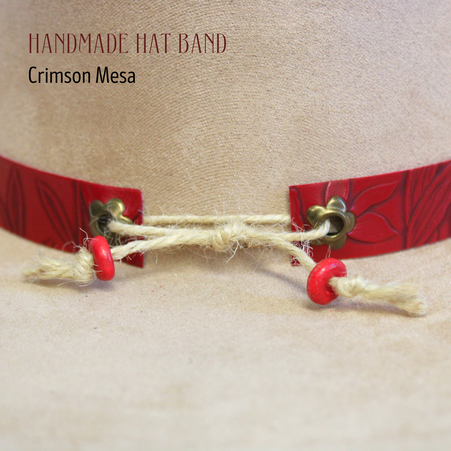 Handmade hat band with red accents and jingle bells on a beige background, featuring the brand 'Crimson Mesa'.