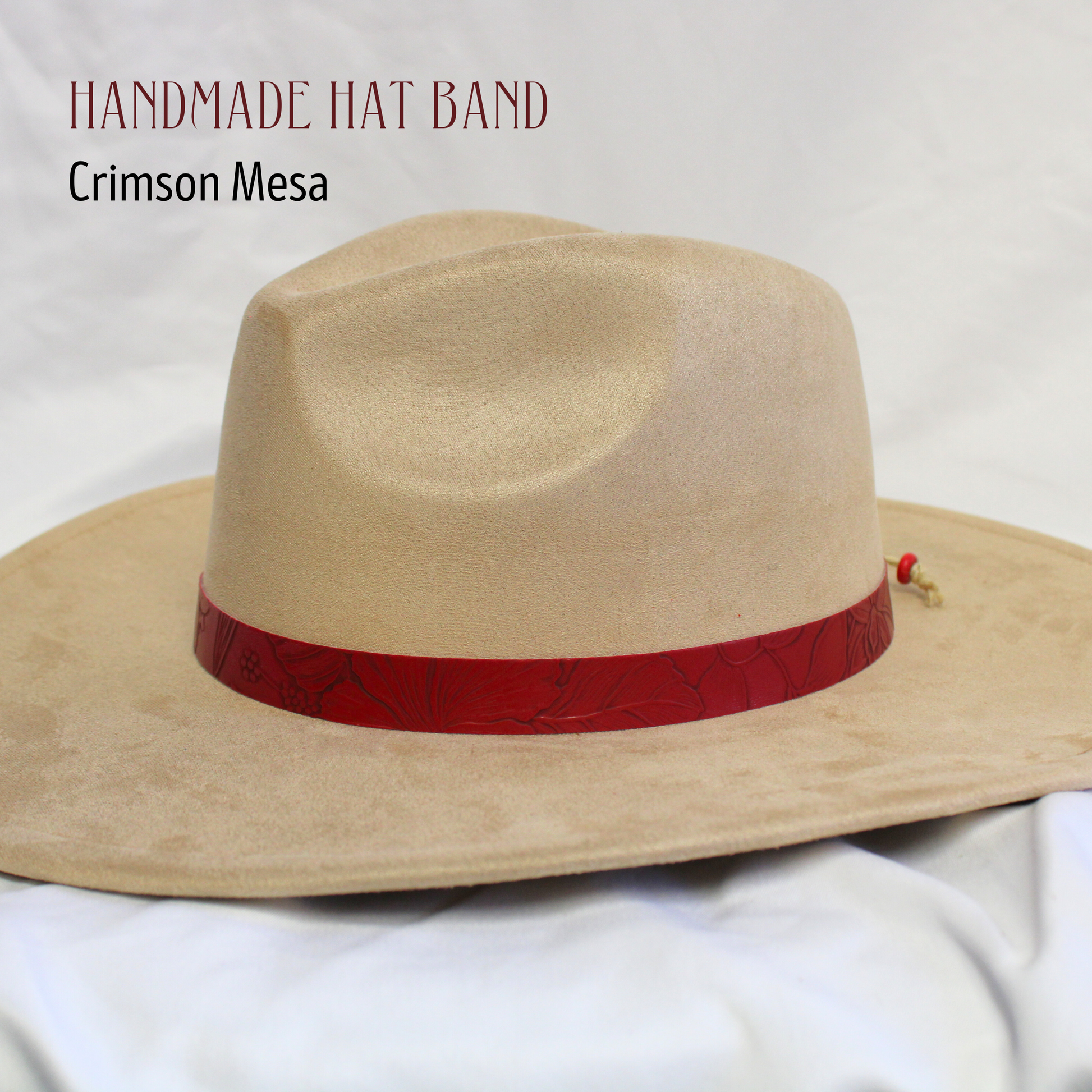 Beige cowboy hat with a red band on a white background, labeled 'Handmade Hat Band Crimson Mesa'.