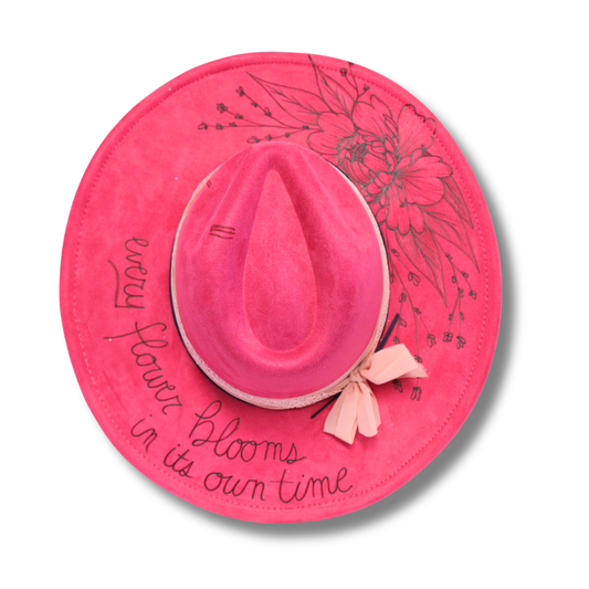 Pink sun hat with floral design and text on a pink circular background