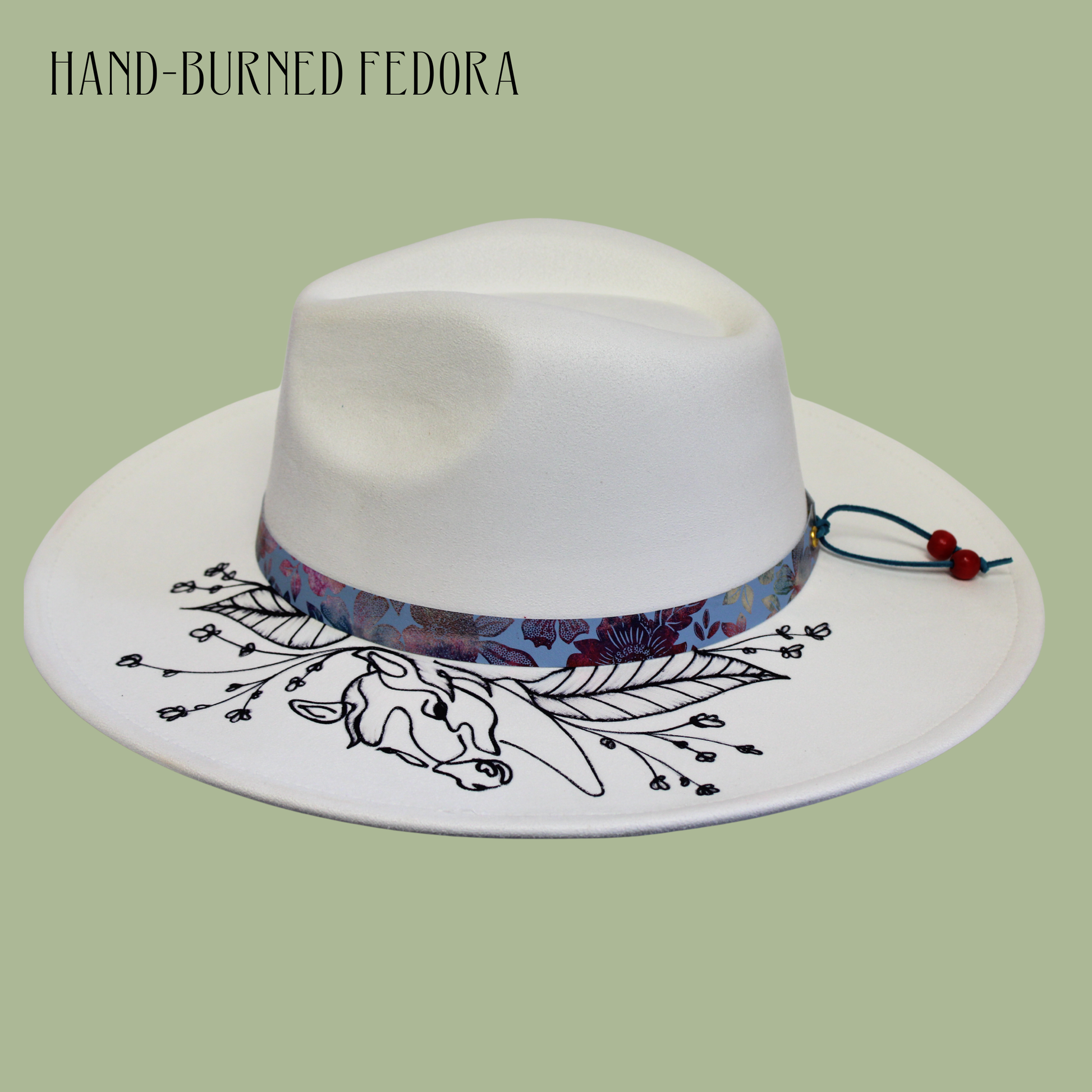 White fedora hat with floral band and horse illustration on a light green background
