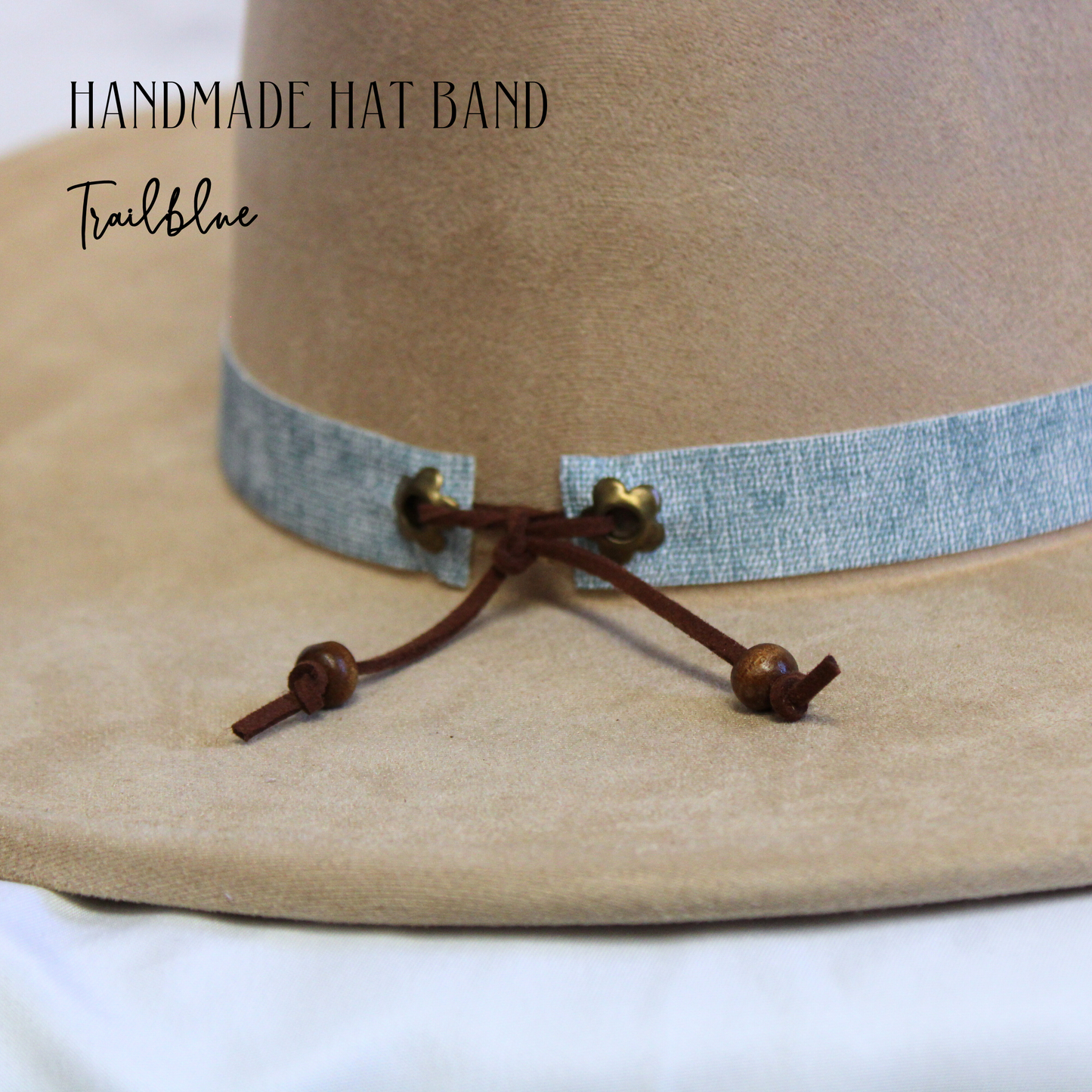 Close-up of a handmade hat band with decorative elements on a beige hat.