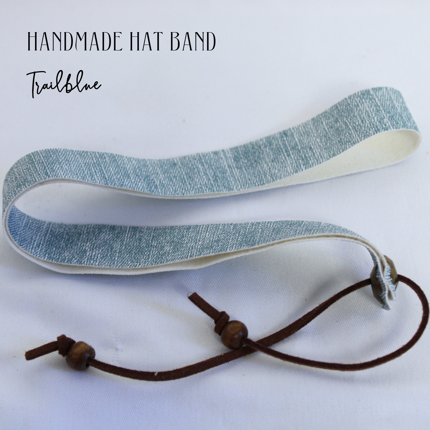 Handmade hat band with blue fabric and brown cord on a white background