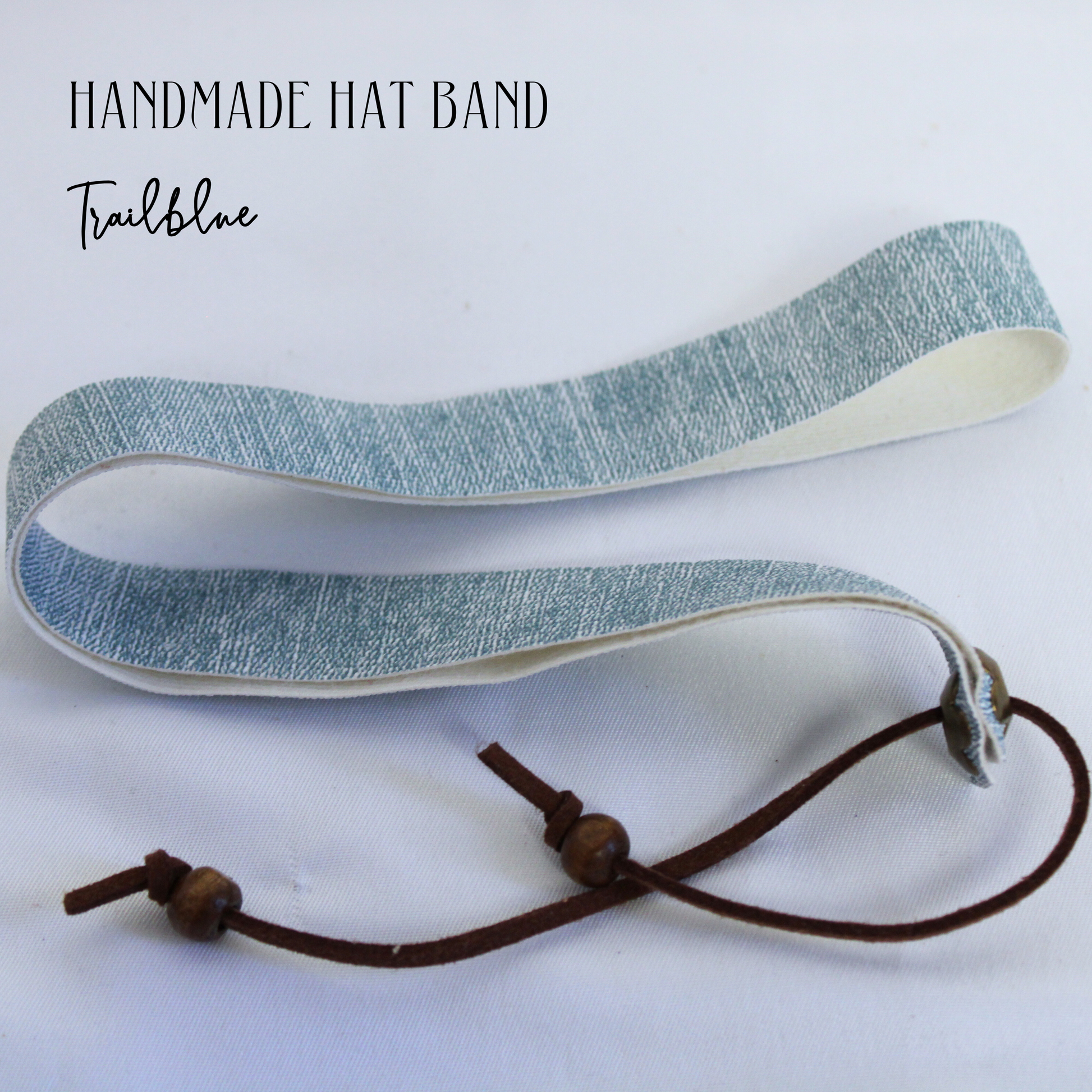 Handmade hat band with blue fabric and brown cord on a white background