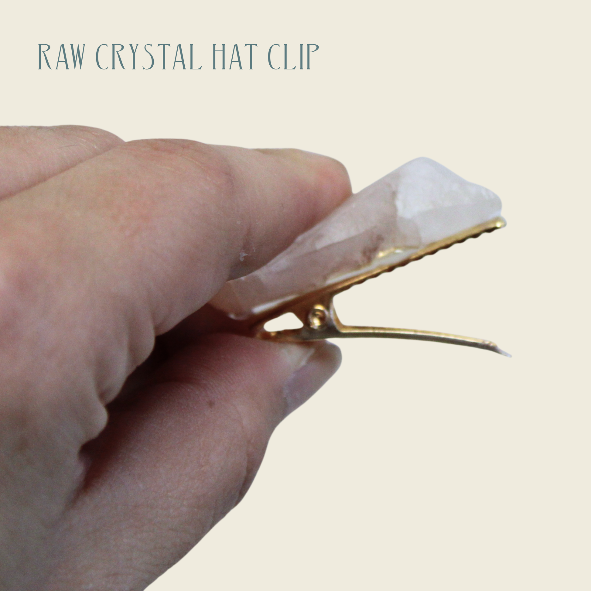 Hand holding a raw crystal hat clip with a beige background