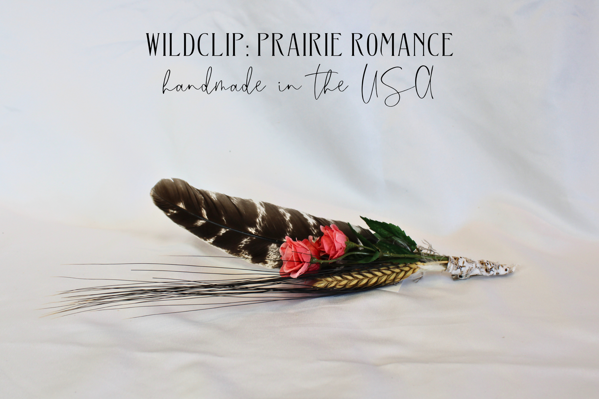 Feather hair clip with pink flower and silver clasp on a light background, labeled 'Wildclip: Prairie Romance'.